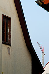 Image showing building crane with old house