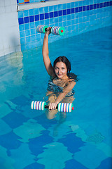 Image showing Attractive girl trains in aqua aerobics