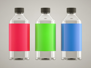 Image showing Three bottles with colorful stickers over grey