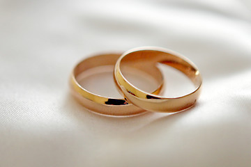 Image showing Two wedding rings with white flower in the background, wedding p