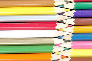 Image showing Assortment of coloured pencils with shadow on white/back backgro