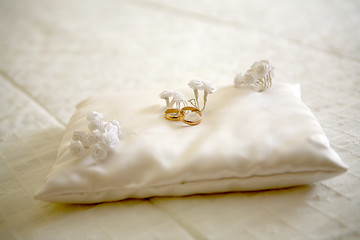Image showing Two wedding rings with white flower in the background, wedding p