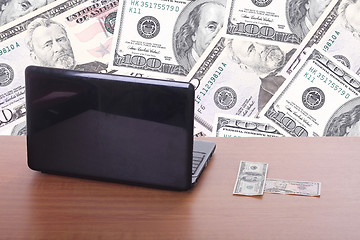 Image showing money flying and pouring out from a notebook computer