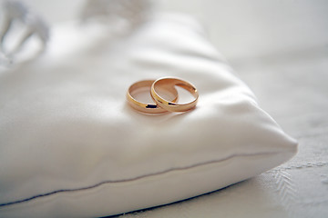 Image showing Two wedding rings with white flower in the background, wedding p