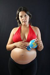Image showing beautiful Pregnant woman with beautiful belly holding a world gl