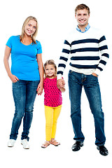 Image showing Sweet little kid standing in between her parents