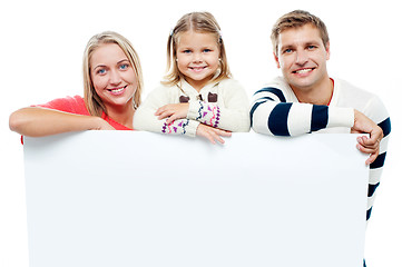 Image showing Smiling family with whiteboard in a studio