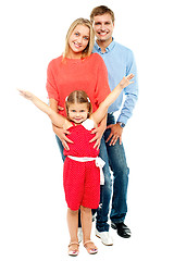 Image showing Cheerful family of three posing indoors