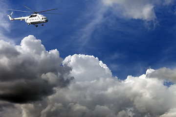 Image showing Helicopter in blue sky with clouds