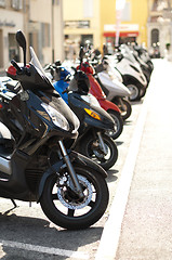 Image showing A line of mopeds/scooters