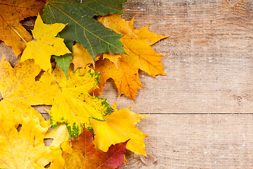 Image showing autumn leaves over wooden background 