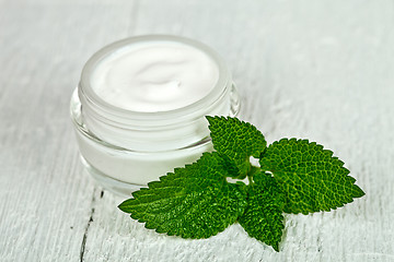 Image showing face cream in glass jar with green leaf of urtica 