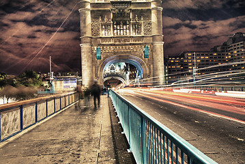 Image showing Tower Bridge in London, UK at night with traffic and moving red 