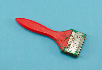 Image showing red broken paint brush tool handle on blue 