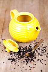 Image showing yellow teapot with spoon and tea 