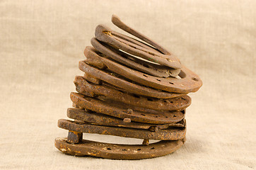 Image showing stack of old retro horse shoes on linen background 