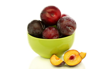 Image showing  Red plums in green bowl.