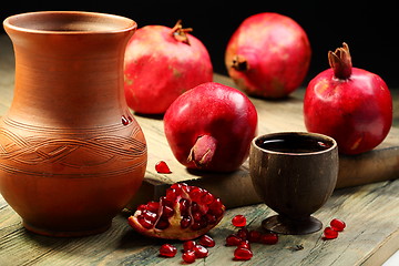 Image showing Fresh juice in cup and ripe pomegranates.