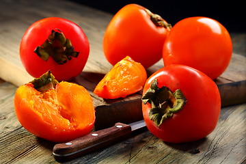 Image showing  Ripe persimmons and knife.