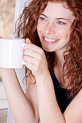 Image showing pretty young redhead woman with freckles and coffe