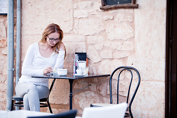 Image showing young woman is drinking coffee outdoor in summer