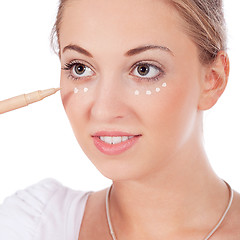 Image showing beautiful woman applying make up on face