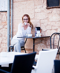 Image showing young woman is drinking coffee outdoor in summer