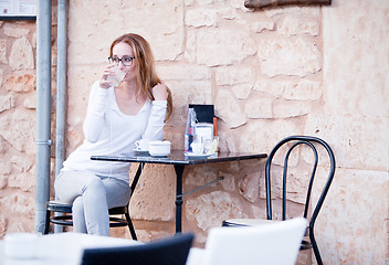 Image showing young woman is drinking coffee outdoor in summer