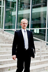 Image showing young business man in black suit with tie outdoor