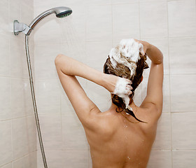 Image showing young brunette woman is taking shower