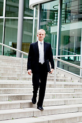 Image showing young business man in black suit with tie outdoor