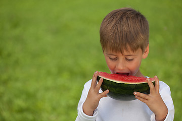 Image showing Little boy eating a watermelon