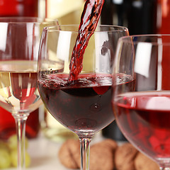 Image showing Red wine pouring into a wine glass