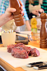 Image showing Man is salting a meat