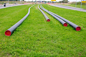 Image showing electricity cable wire protective tube on meadow 