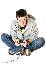 Image showing Furious young man with a joystick for game console