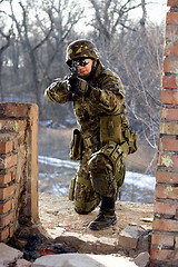 Image showing Soldier sitting near wall with a gun