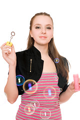 Image showing Portrait of smiling young woman blow bubbles