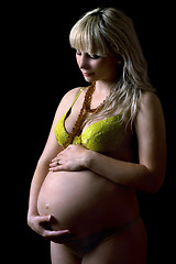 Image showing Young pregnant woman in yellow lingerie. Isolated