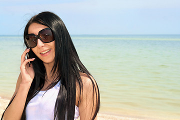 Image showing smiling brunette speaking on the phone