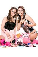 Image showing Two pretty girls blow bubbles. Isolated