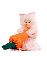 Image showing Baby girl plays with a carrot. Isolated