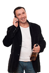 Image showing Smiling man with a phone and bottle of scotch