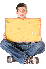 Image showing Surprised young man holding yellow board