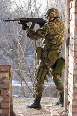 Image showing Soldier standing near wall with a gun