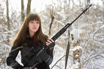 Image showing Armed young lady with a gun