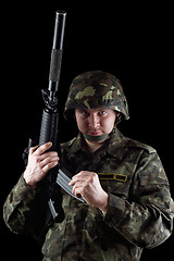 Image showing Soldier reloading magazine of m16 