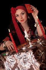 Image showing Gypsy woman sitting with cards. Isolated