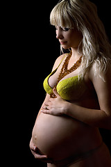 Image showing Pregnant young woman in yellow lingerie. Isolated