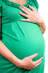 Image showing Belly of a pregnant girl in green dress. Isolated